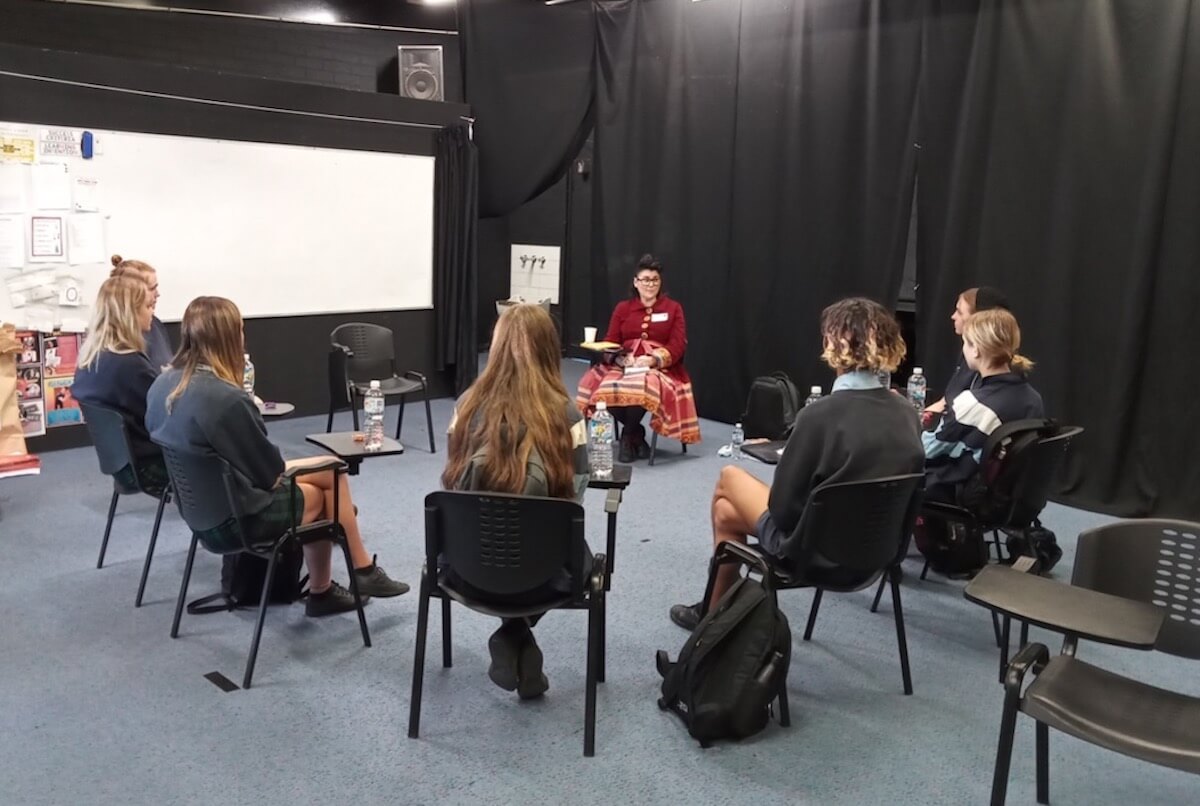 Alana addressing a group of students seated in a circle